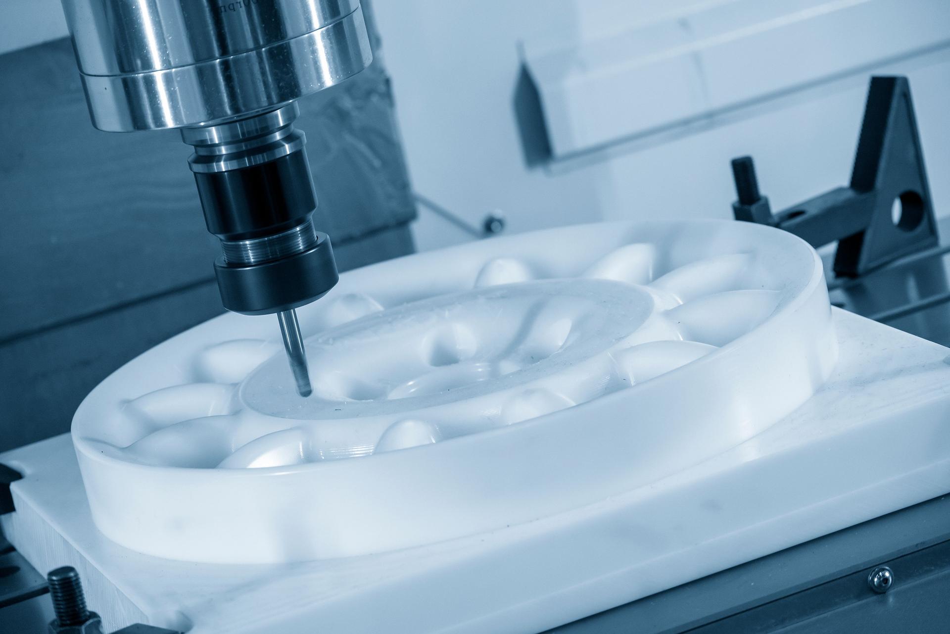 The  CNC  milling machine cutting  the engineering plastic material part by solid ball  end-mill tool.