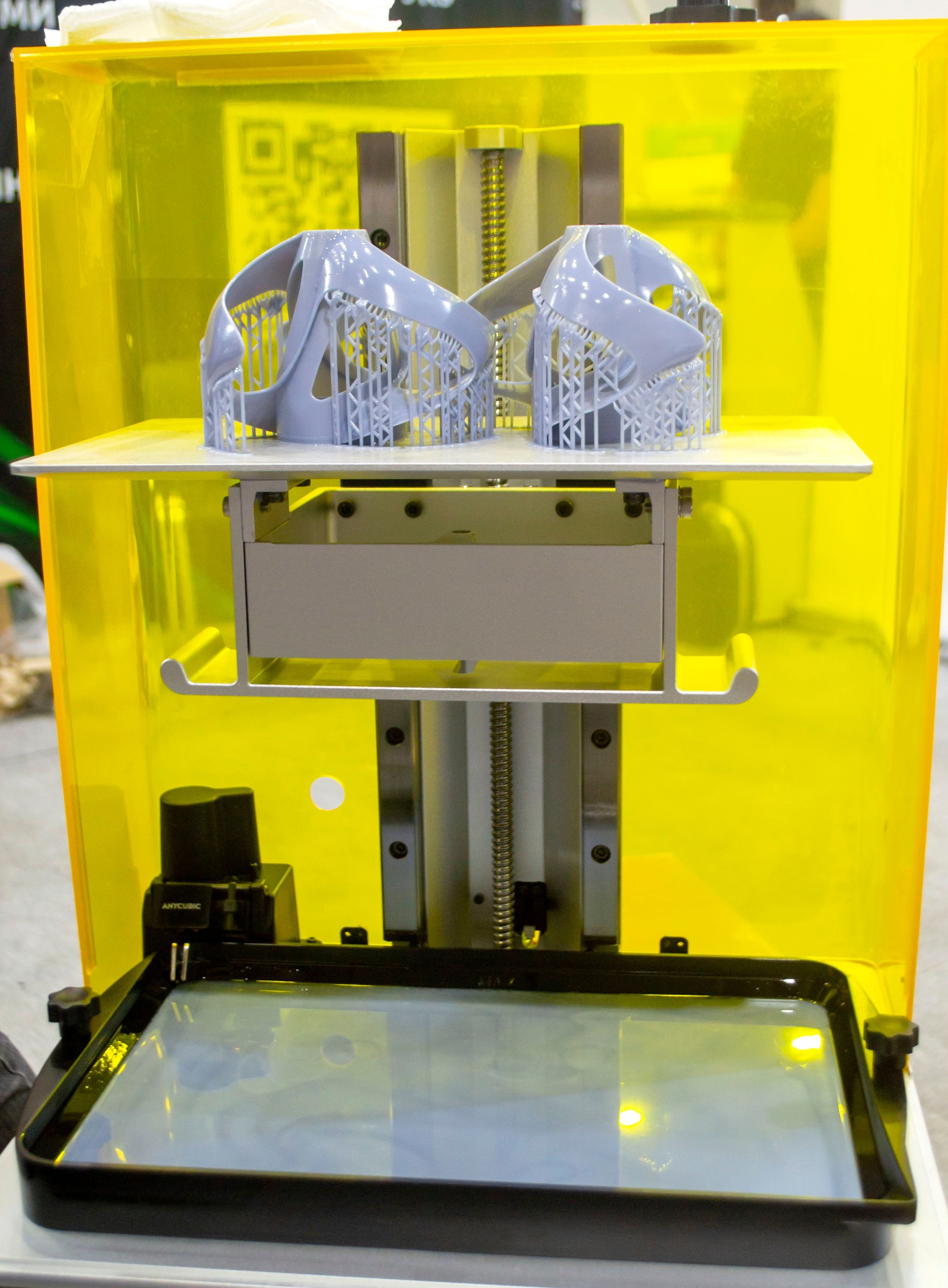 Printed models on 3D printer close-up. Objects printed on photopolymer sla 3D printer from liquid photopolymer resins on printing platform inside 3d printer. Modern progressive additive technology.